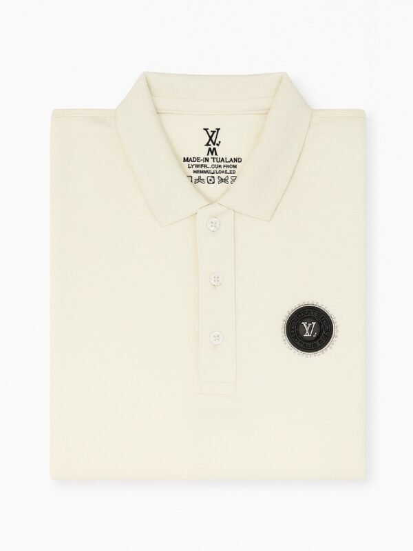 Cream-colored short-sleeve polo shirt with three-button placket and black circular embroidered chest logo on a white background.